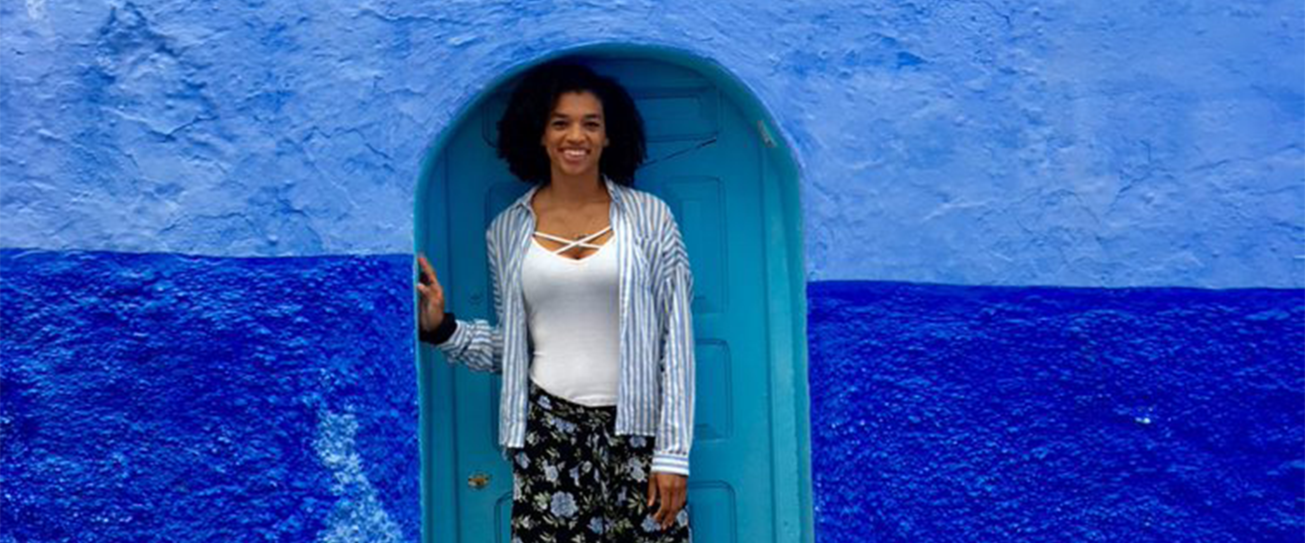 Michael posing in front of one of the blue doors in Morocco, during her study abroad experience