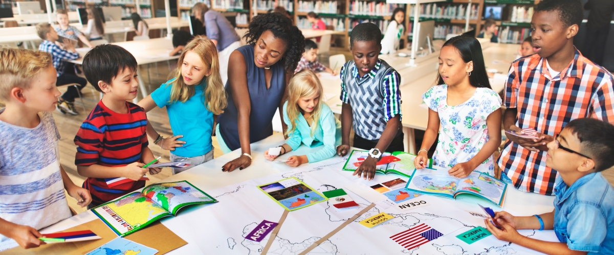 Students gathered around their teacher_AdobeStock