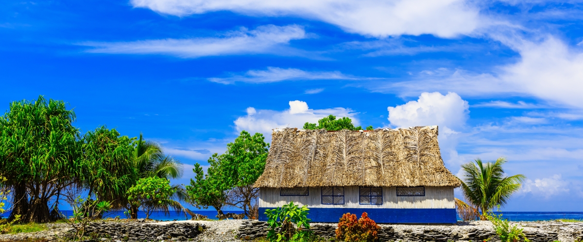 Village on South Tarawa atoll, Kiribati, Gilbert islands, Micronesia, Oceania. Thatched roof houses. Rural life, a remote paradise island under palms