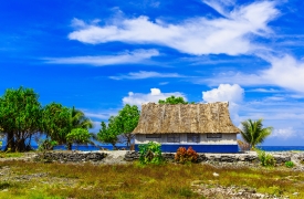 Village on South Tarawa atoll, Kiribati, Gilbert islands, Micronesia, Oceania. Thatched roof houses. Rural life, a remote paradise island under palms