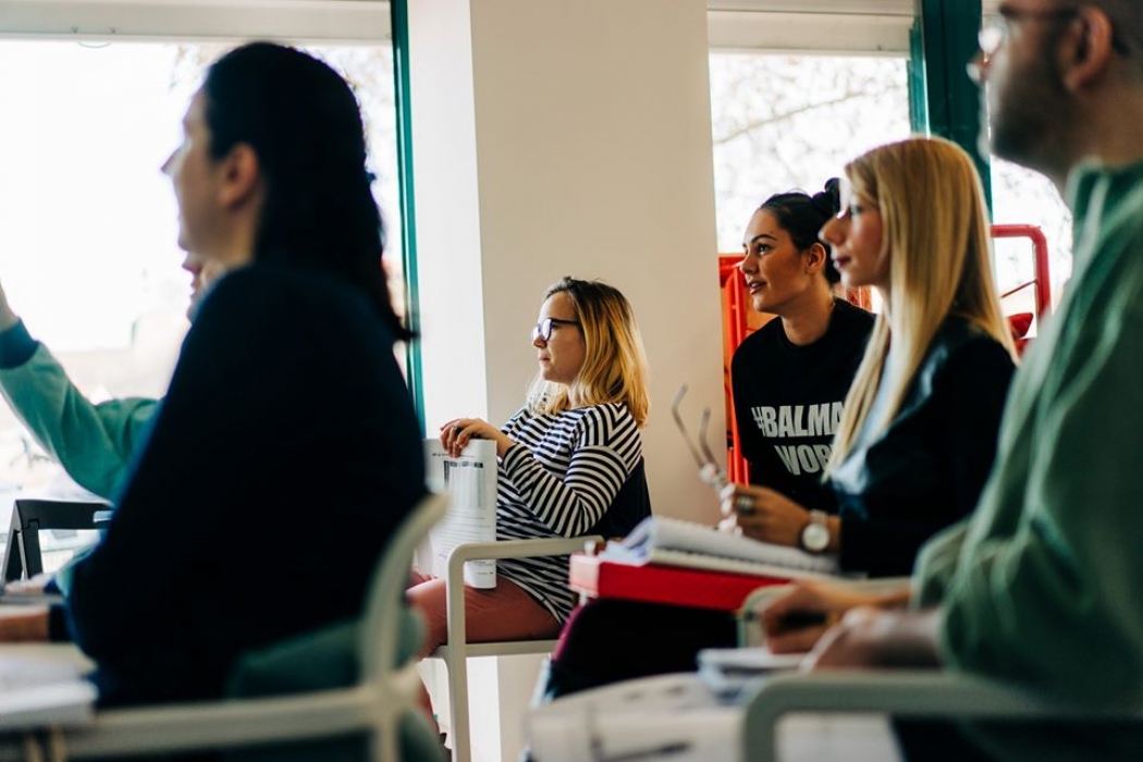 Students seated at desks facing an instructor during a BELL+ class