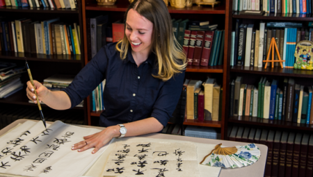 Leigh Lawrences practices her Chinese calligraphy skills with a smile, paintbrush in hand